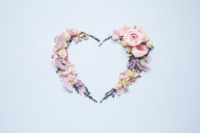 Photo of Beautiful heart shaped floral composition on light background, flat lay