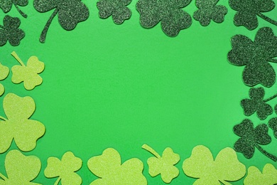 Frame of clover leaves on light green background, flat lay with space for text. St. Patrick's Day celebration