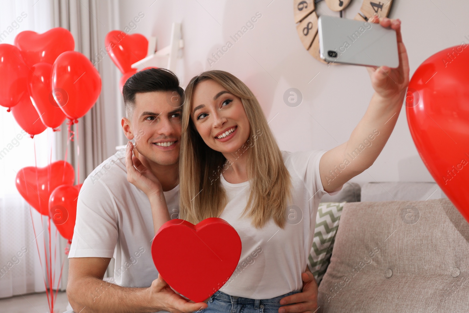 Photo of Lovely couple taking selfie at home. Valentine's day celebration