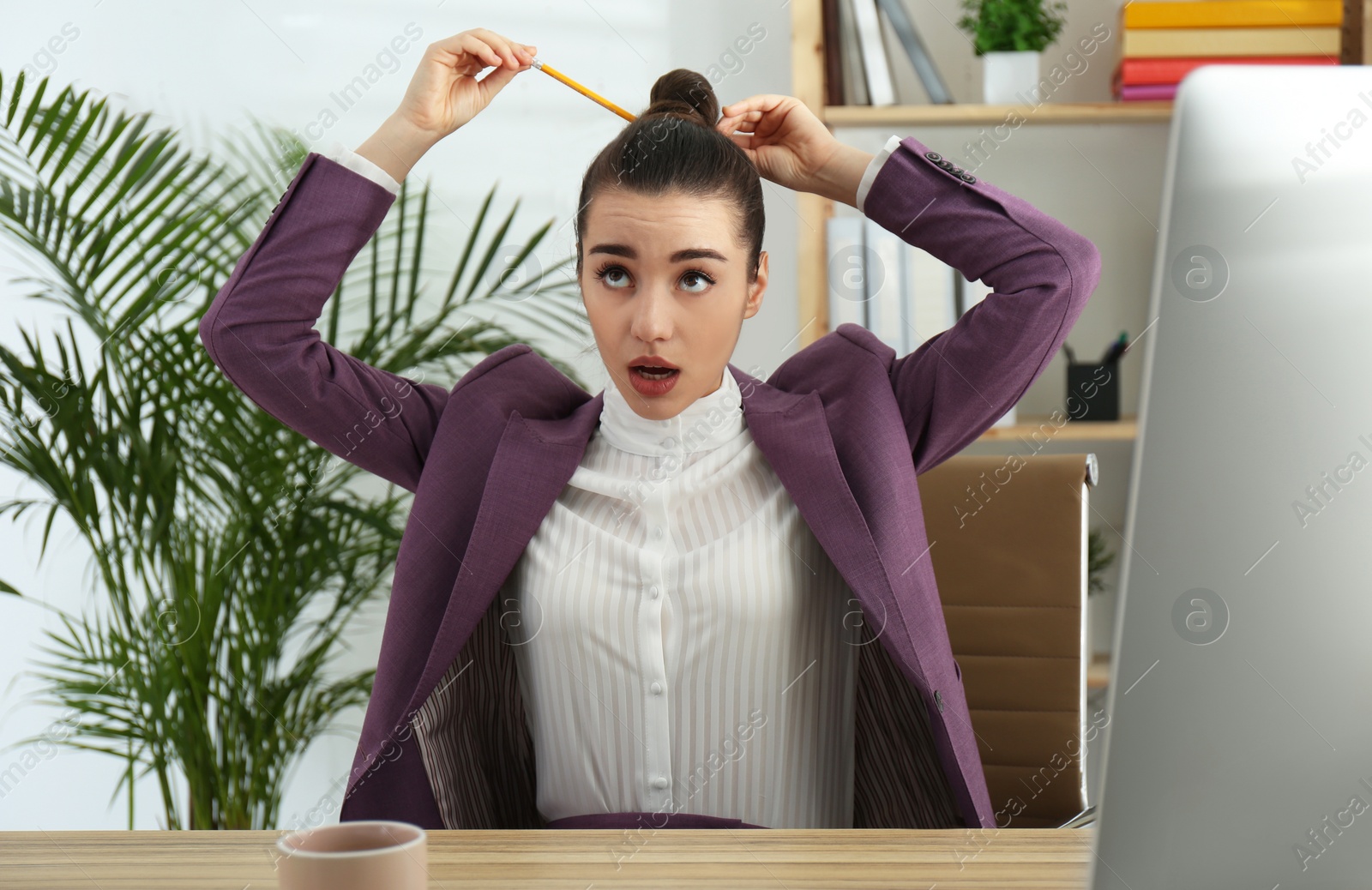 Photo of Lazy employee playing with pencil at table in office