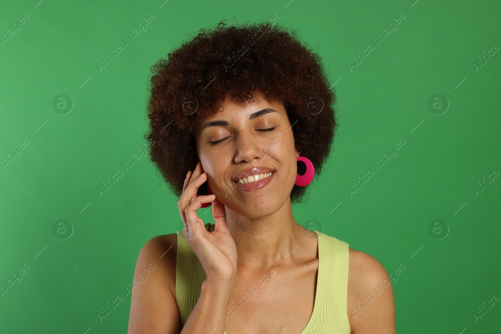 Photo of Portrait of happy young woman on green background