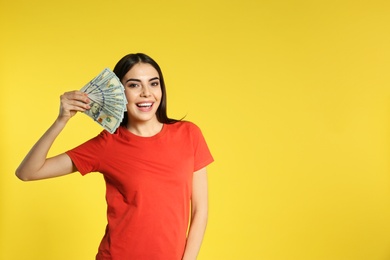 Young woman with money on color background. Space for text