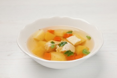 Photo of Dish with fresh homemade chicken soup on wooden table