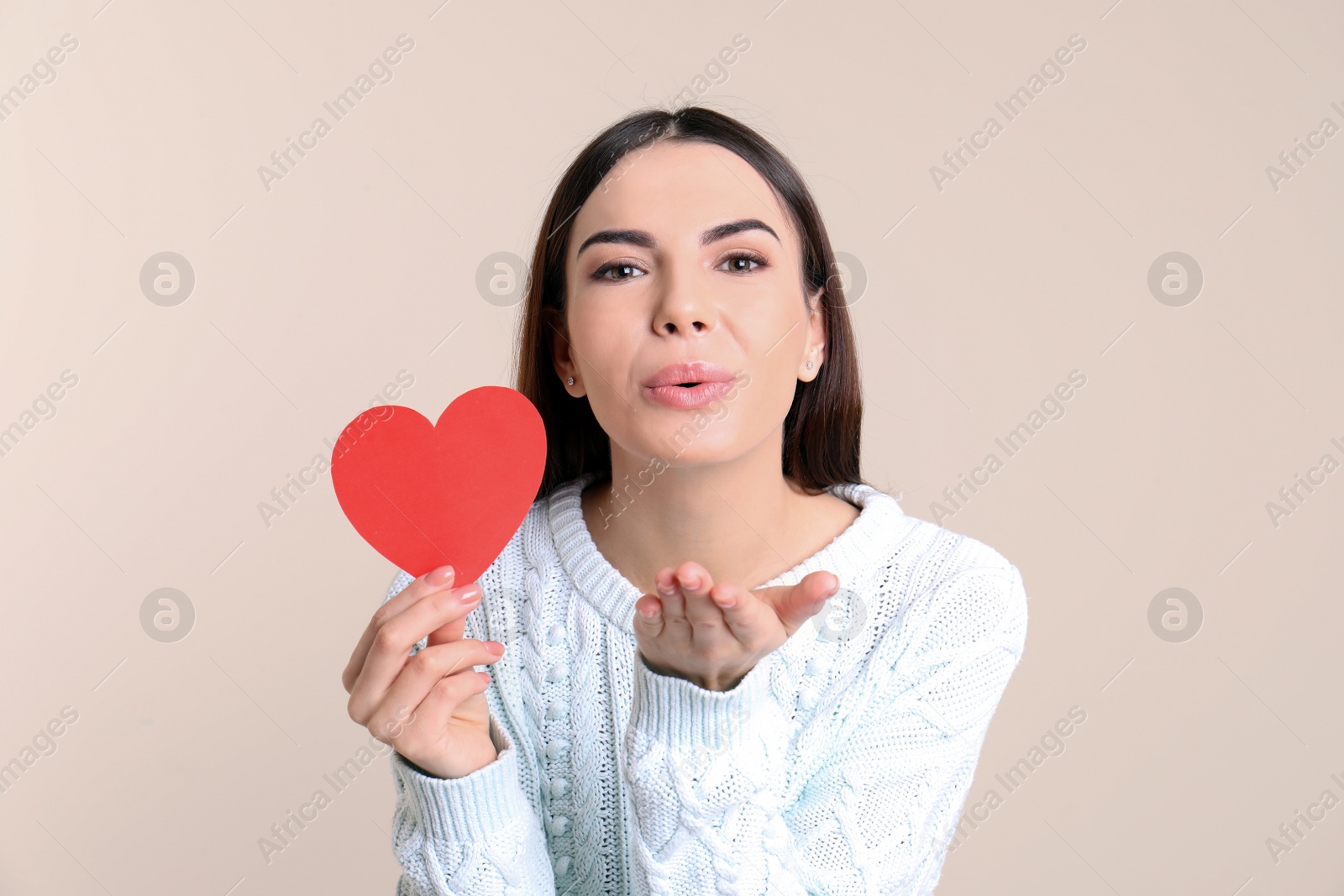 Photo of Portrait of young woman with paper heart on color background