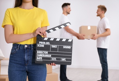 Photo of Operator holding clapperboard during the production indoors, closeup