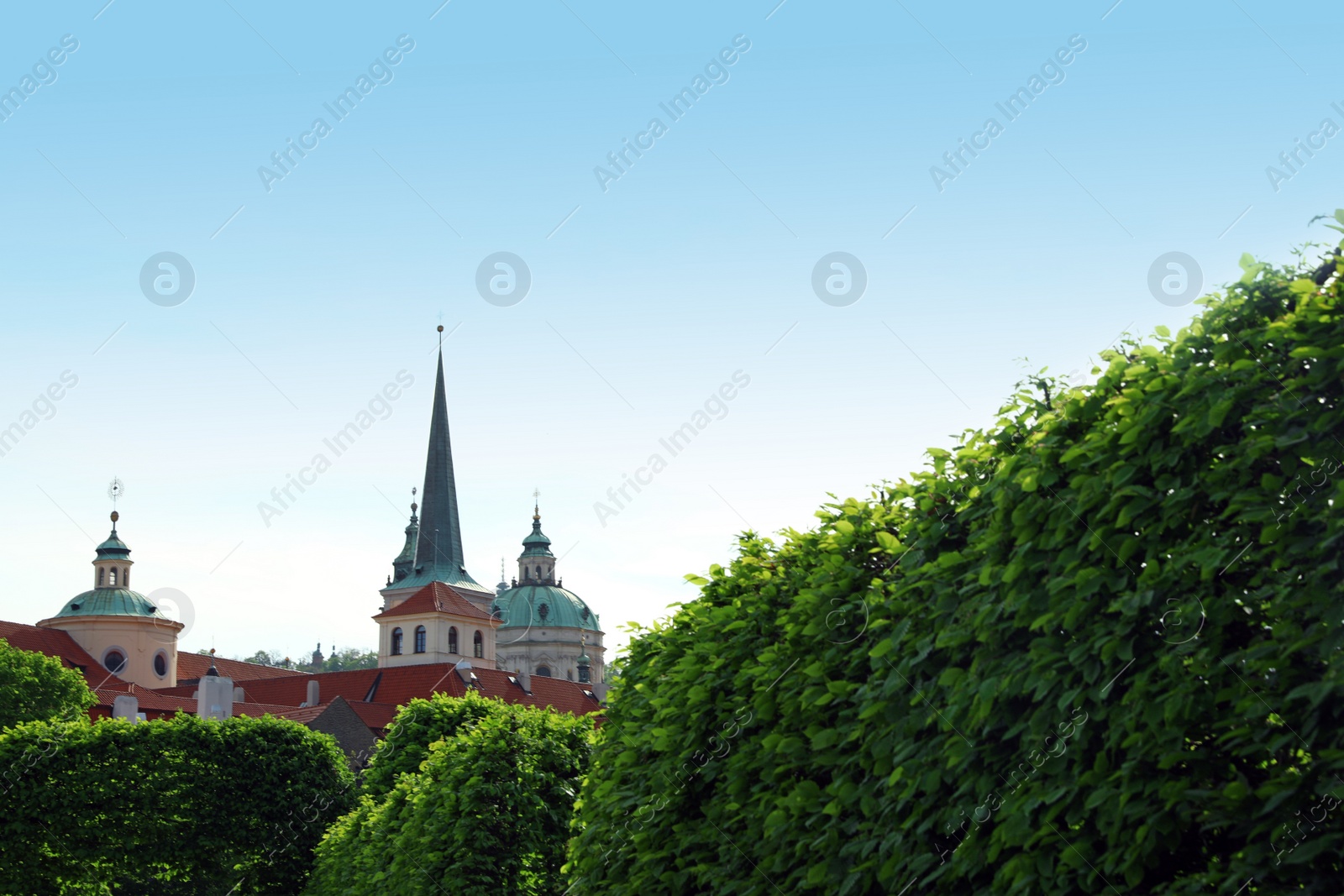 Photo of PRAGUE, CZECH REPUBLIC - APRIL 25, 2019: View of Saint Nicholas Church domes from Wallenstein Palace garden