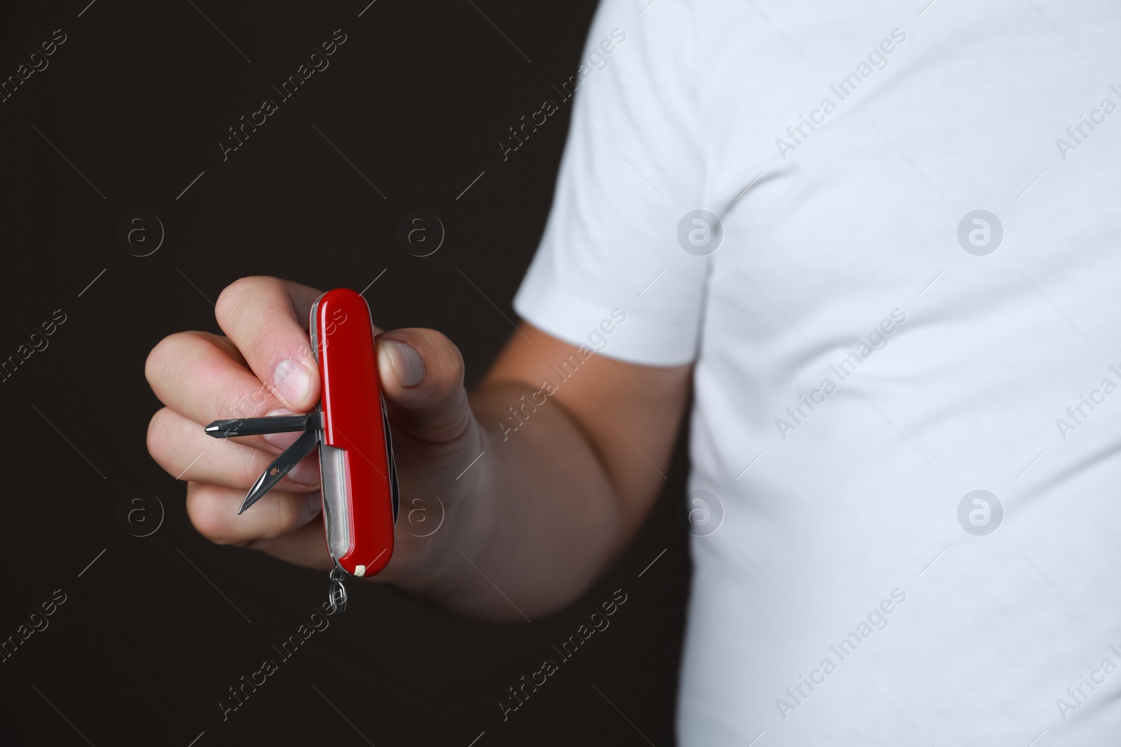 Photo of Man holding multitool on dark background, closeup