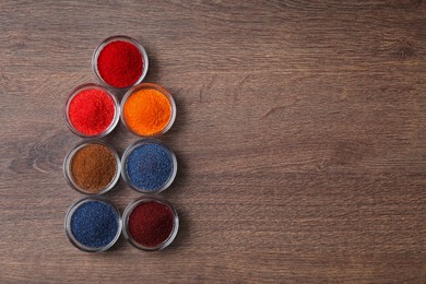 Many different food coloring on wooden table, flat lay. Space for text