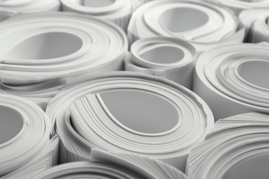 Photo of Rolled white paper sheets as background, closeup