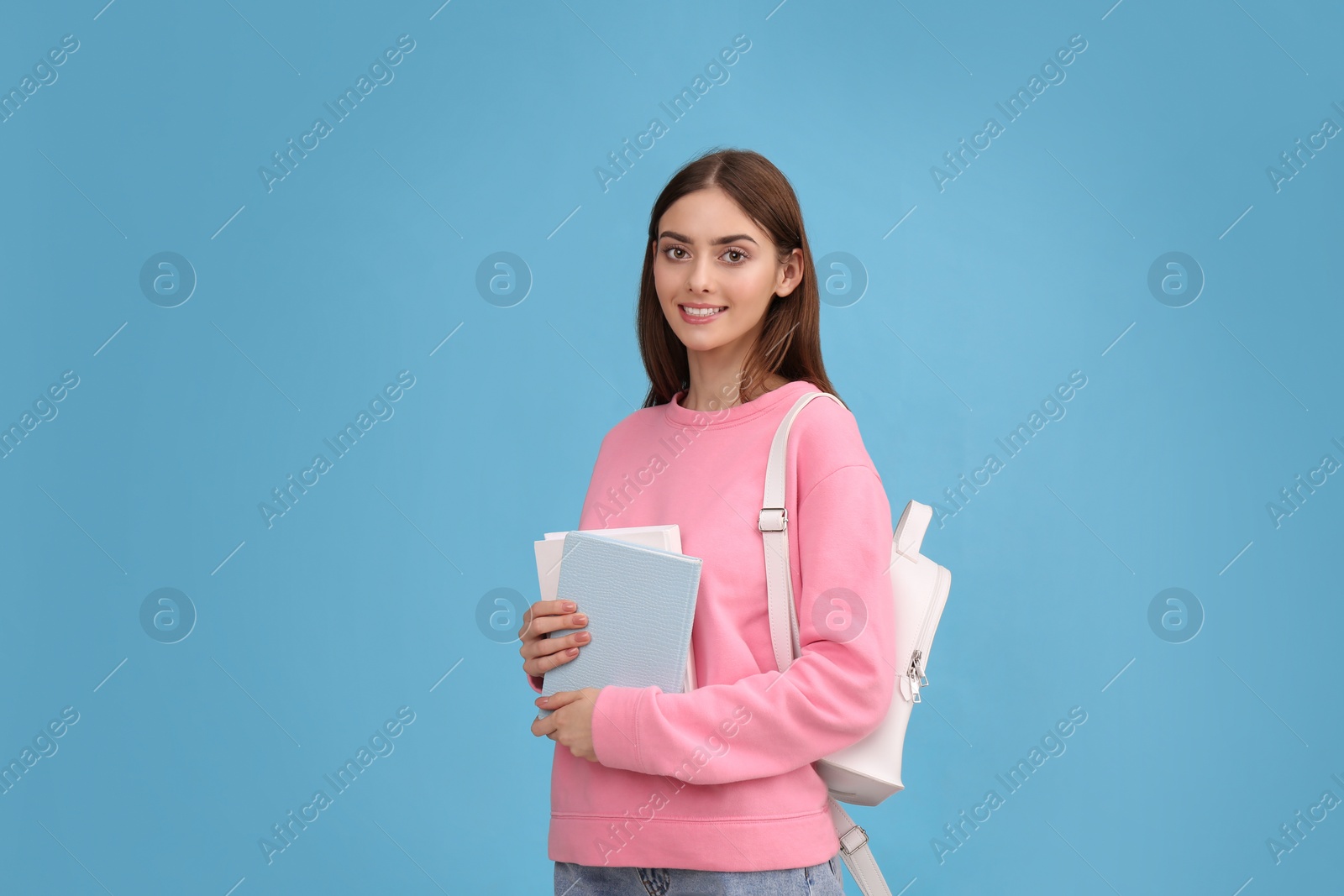 Photo of Teenage student with books and backpack on turquoise background