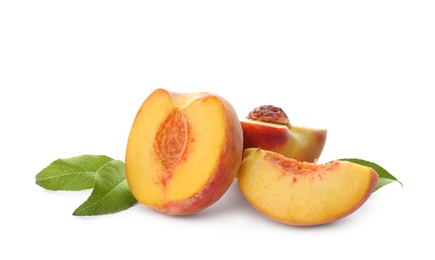 Photo of Cut fresh ripe peaches with leaves on white background