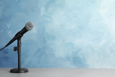 Photo of Microphone on table against color background. Space for text