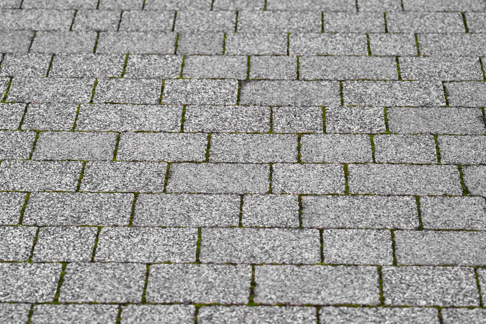 Photo of View on grey stone sidewalk. Footpath covering