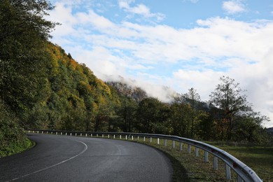 Photo of Picturesque view of empty road near trees in mountains