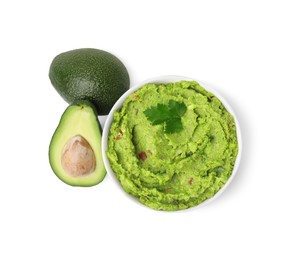 Photo of Bowl of delicious guacamole and fresh avocados isolated on white, top view