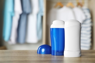 Deodorants on wooden table indoors. Space for text