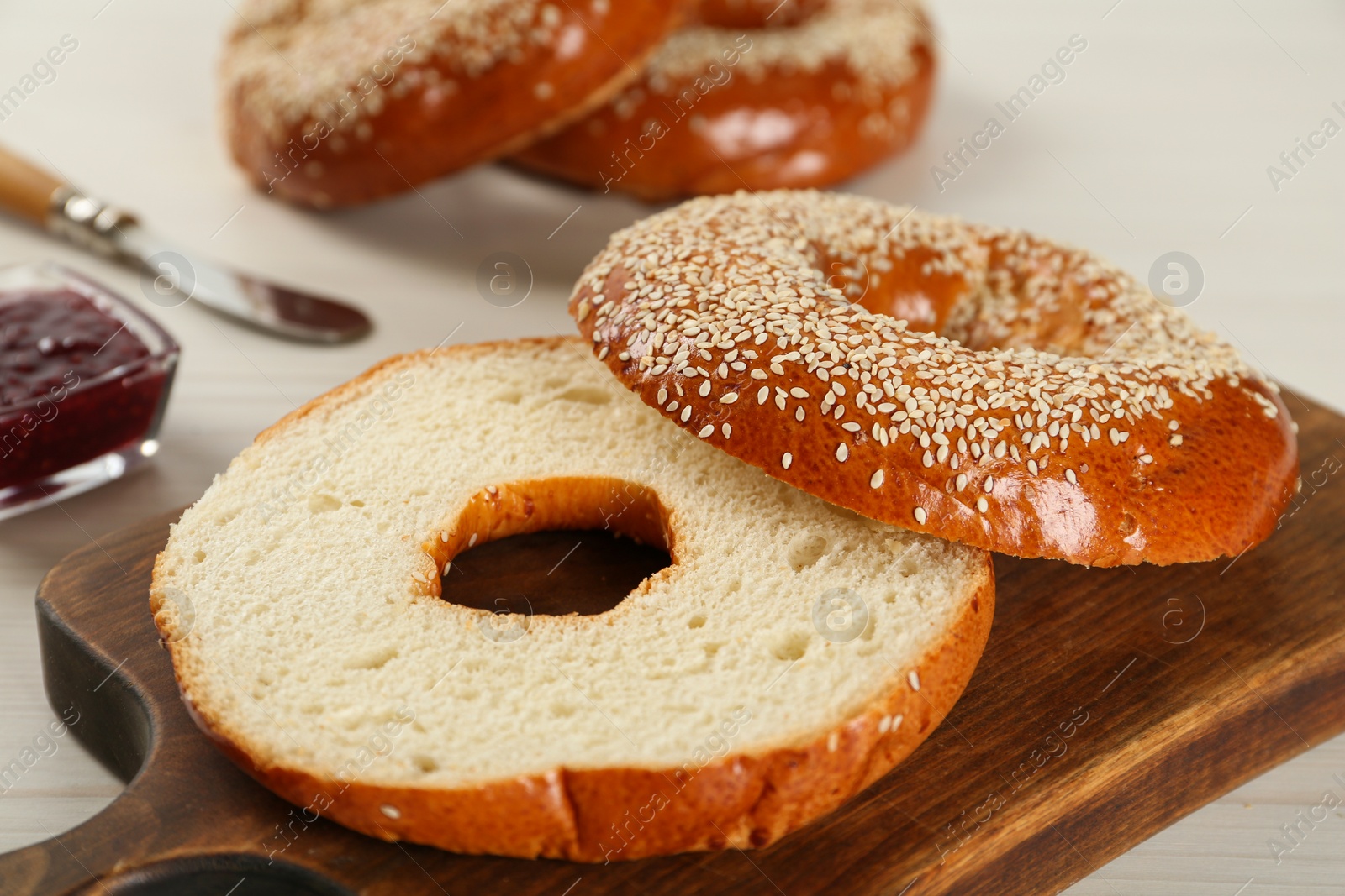 Photo of Delicious fresh halved bagel on white table, closeup