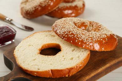 Delicious fresh halved bagel on white table, closeup