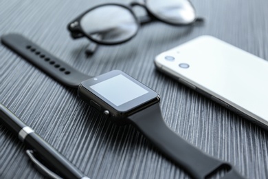 Photo of Composition with stylish smart watch on black table, closeup