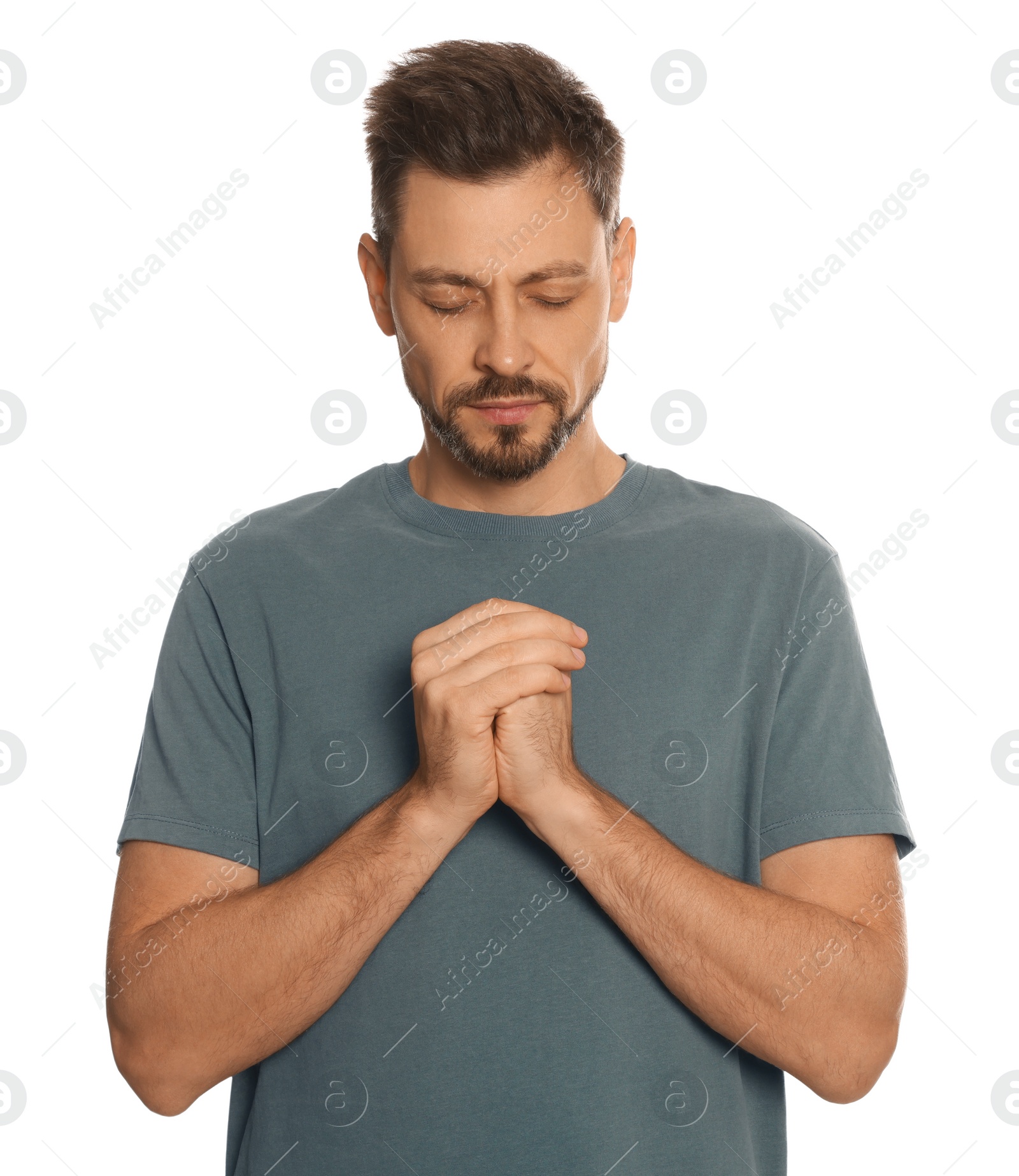 Photo of Man with clasped hands praying on white background