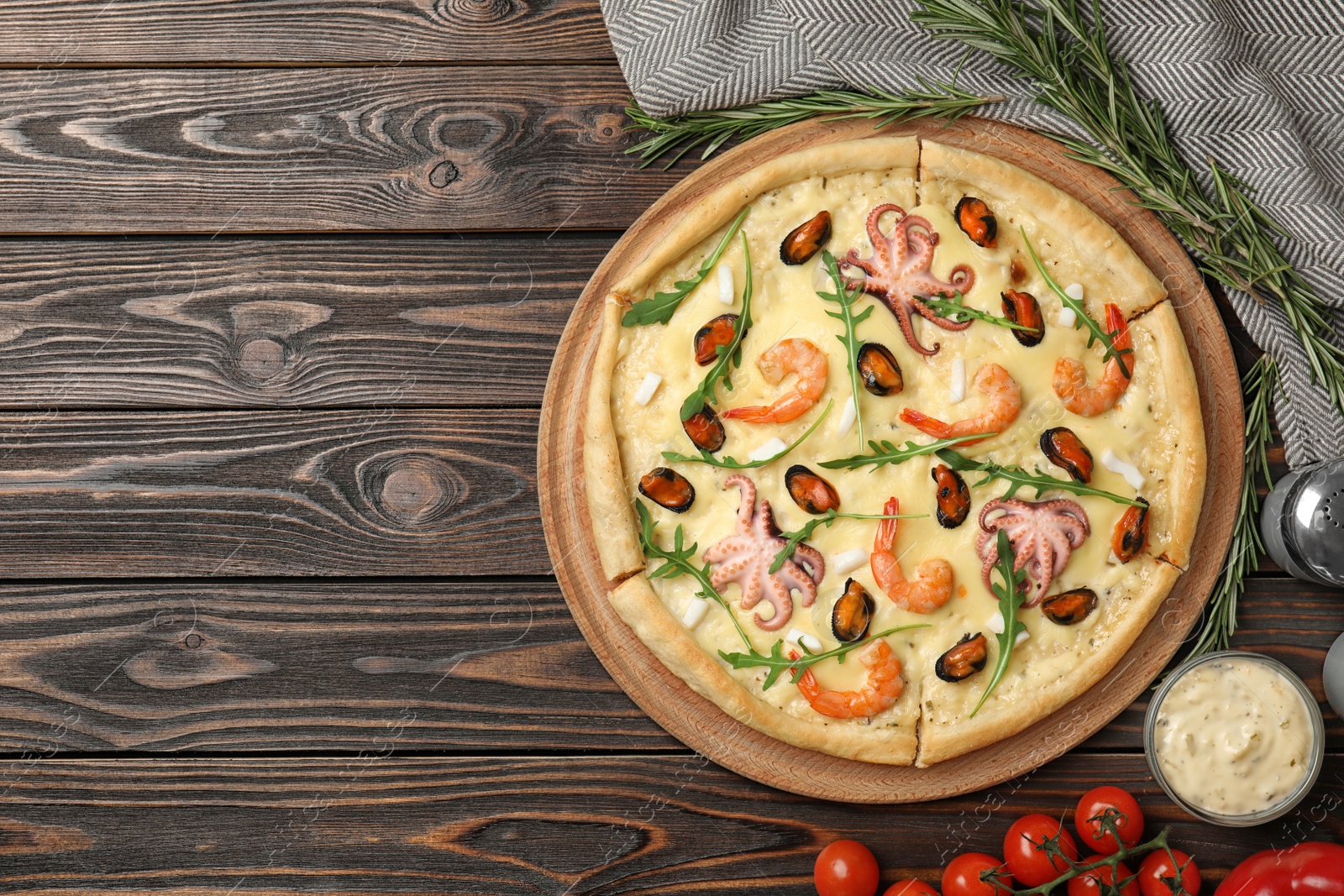 Photo of Delicious seafood pizza on wooden table, flat lay. Space for text