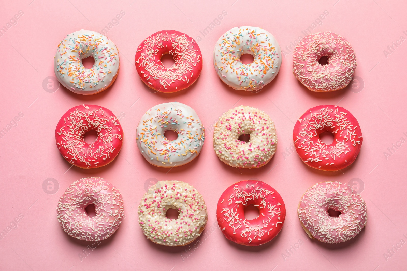 Photo of Delicious glazed doughnuts on color background, top view