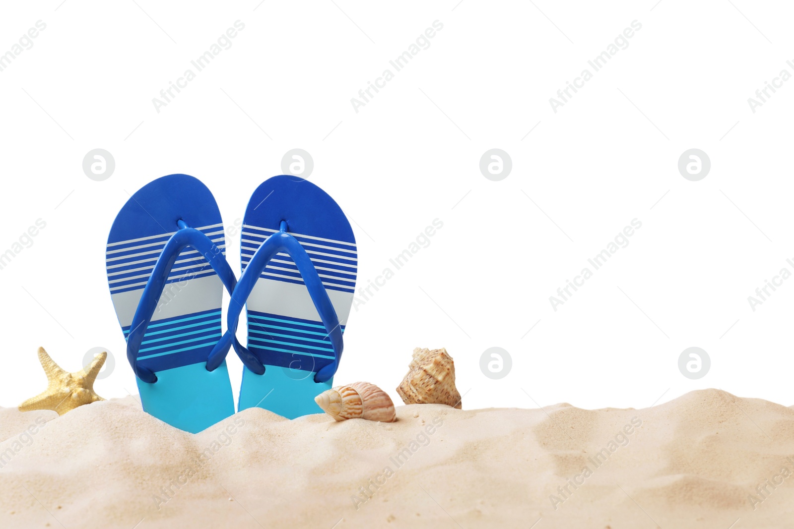 Photo of Striped flip flops, starfish and sea shells on sand against white background