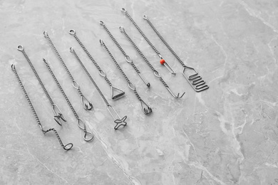 Photo of Set of different logopedic probes on marble table. Speech therapist's tools