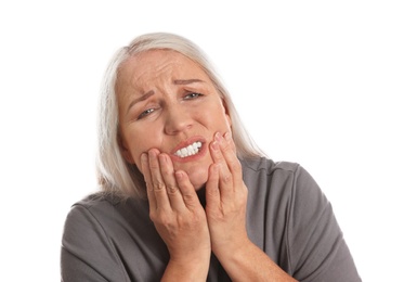 Mature woman suffering from toothache on white background
