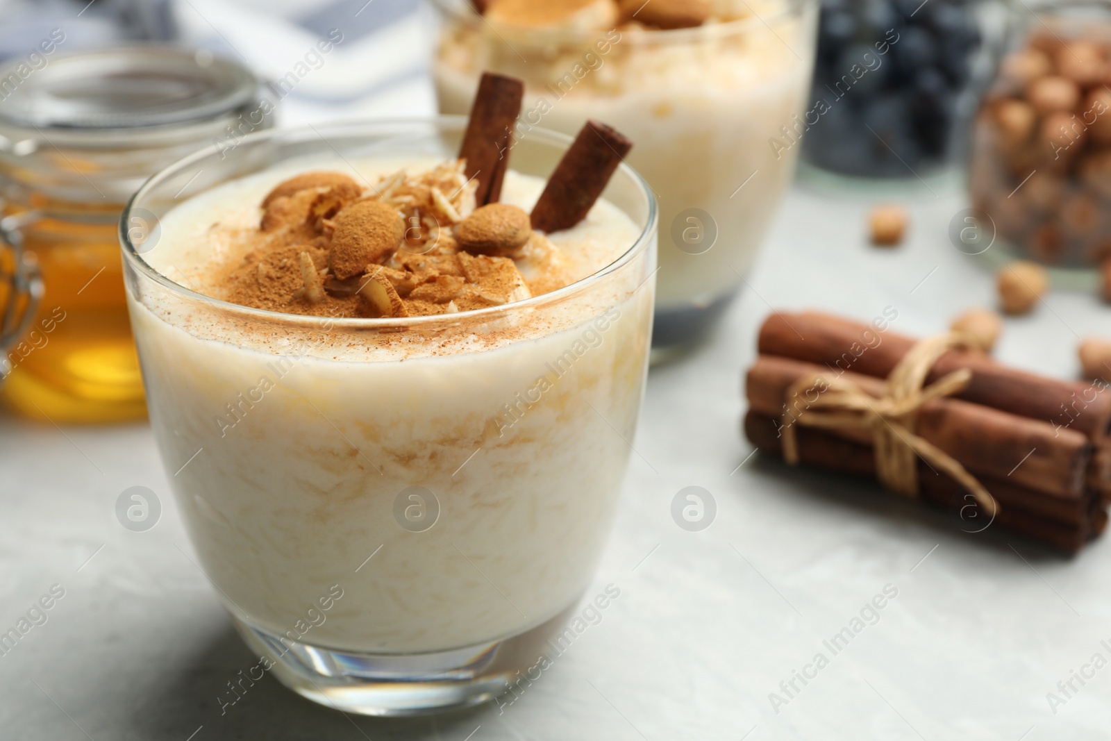 Photo of Delicious rice pudding with almonds and cinnamon on  marble table, closeup