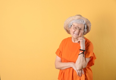 Portrait of cool grandmother on color background, space for text