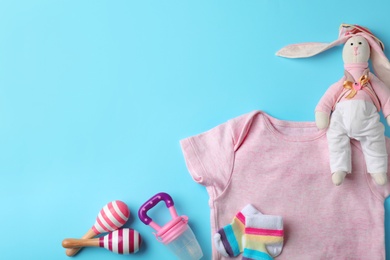Photo of Flat lay composition with stylish baby clothes and toys on color background. Space for text
