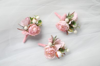 Wedding stuff. Stylish boutonnieres on white veil, flat lay