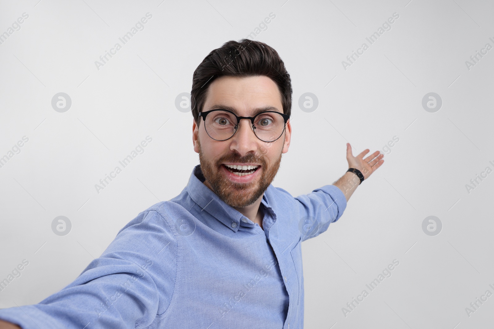 Photo of Smiling man taking selfie on white background