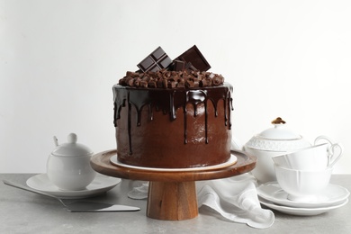 Photo of Freshly made delicious chocolate cake on grey table against white background