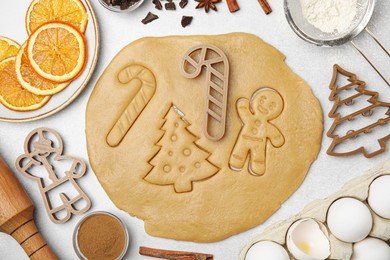 Christmas treat. Flat lay composition with cookie cutters and dough on light table