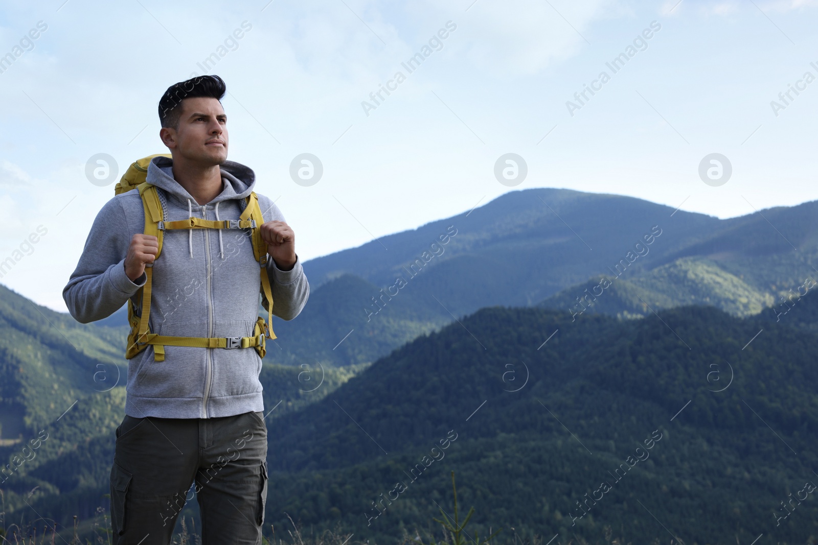 Photo of Tourist with backpack in mountains, space for text