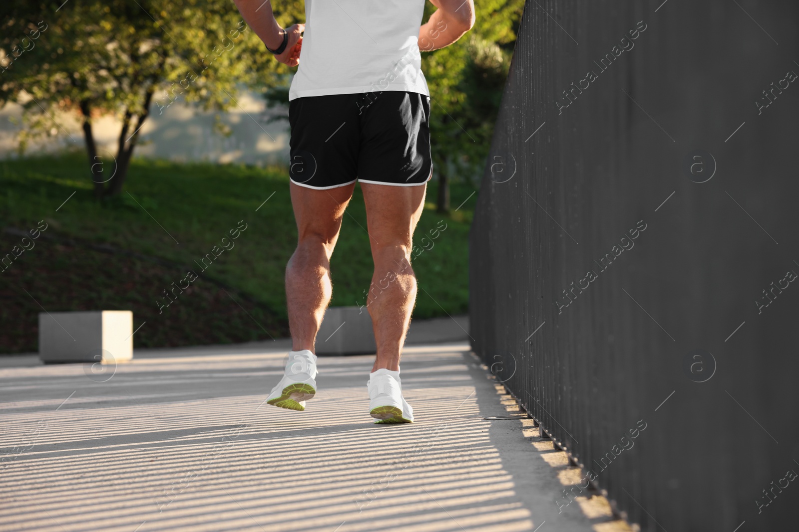 Photo of Man running outdoors on sunny day, closeup