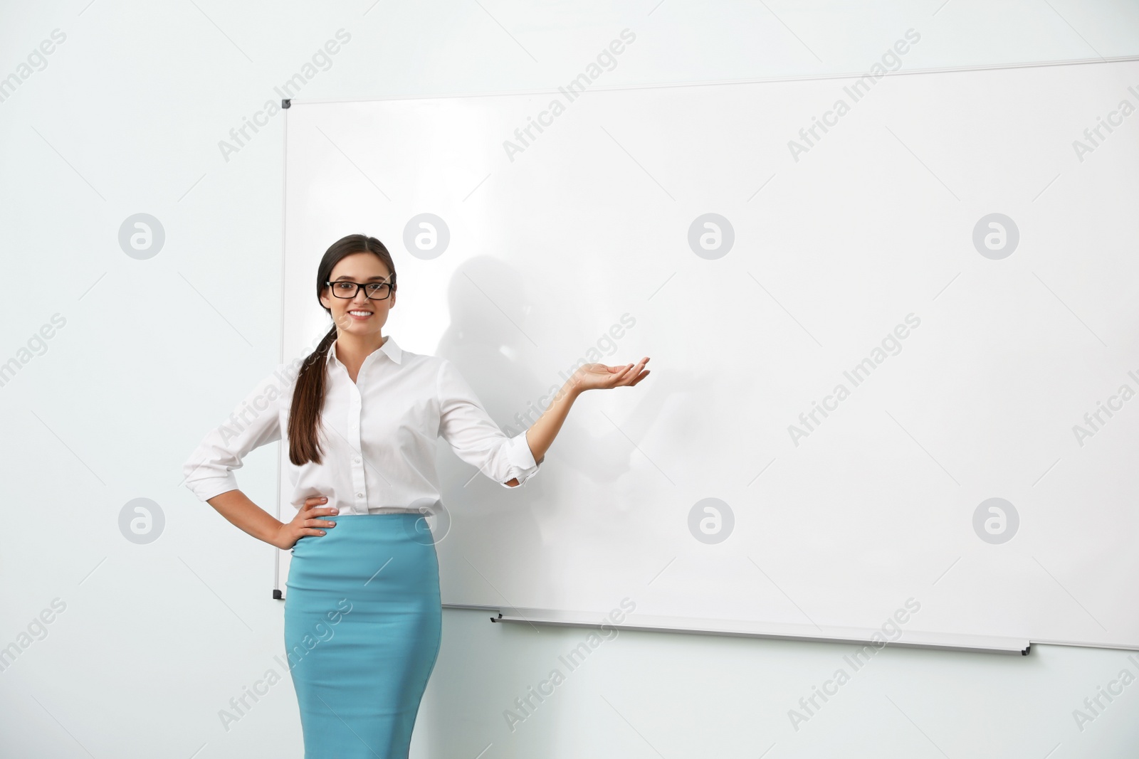 Photo of Female teacher near whiteboard in modern classroom