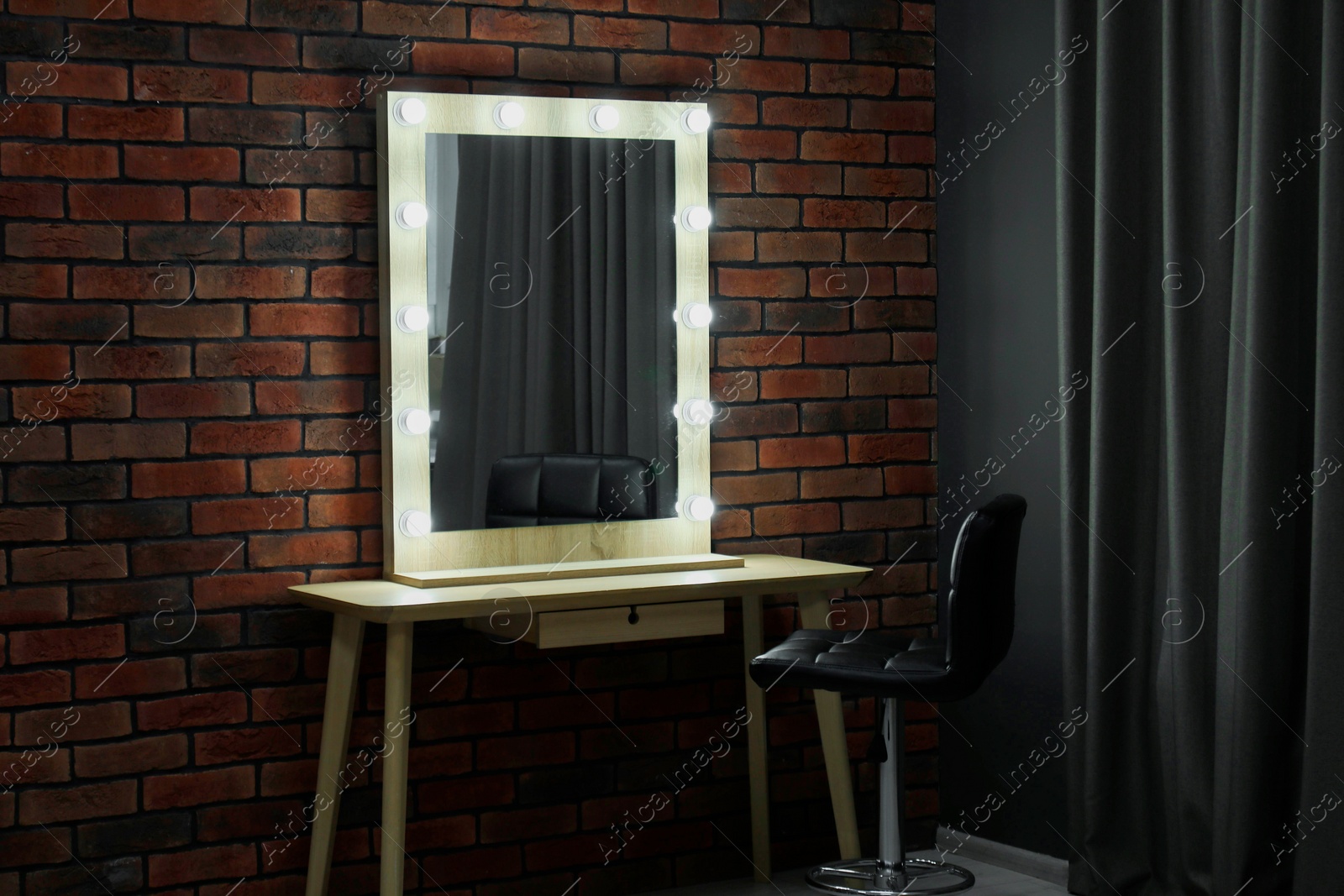 Photo of Mirror with light bulbs, table, chair and curtain in makeup room