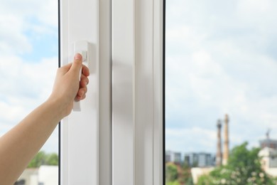 Photo of Woman opening white plastic window indoors, closeup. Space for text