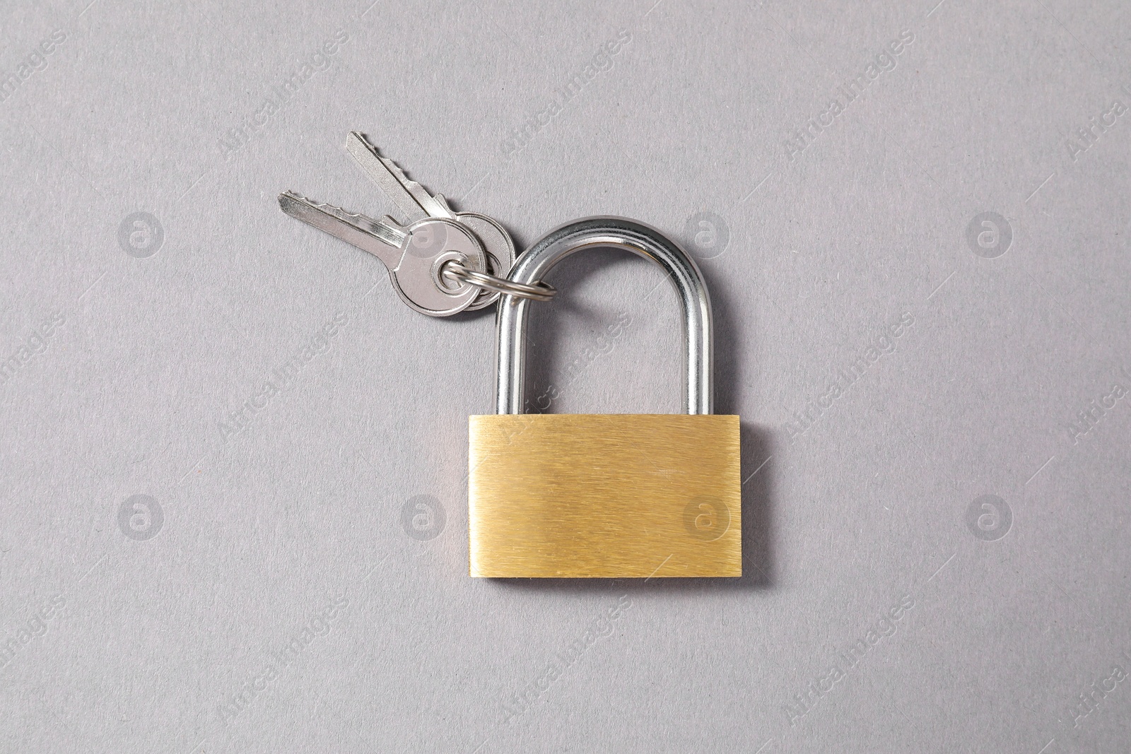 Photo of Steel padlock with keys on grey background, top view
