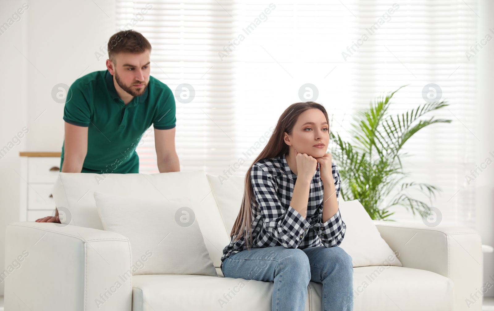 Photo of Unhappy young couple with relationship problems at home