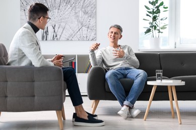 Photo of Professional psychotherapist working with patient in office