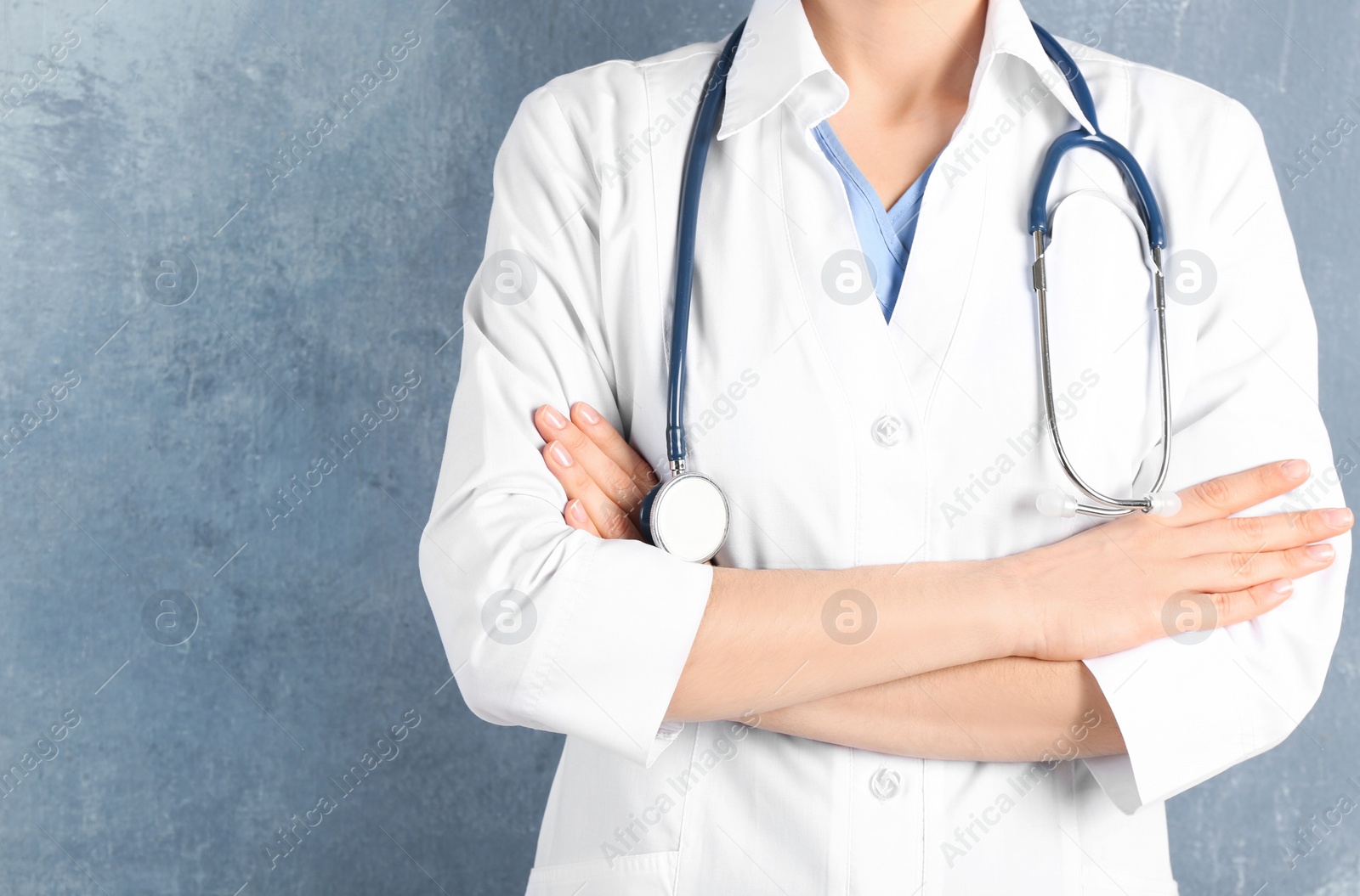 Photo of Doctor with stethoscope on blue background, closeup. Medical service