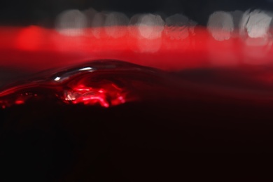 Delicious red wine in glass as background, closeup