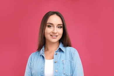 Photo of Beautiful young woman in casual outfit on crimson background