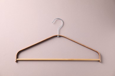 Photo of One wooden hanger on beige background, top view