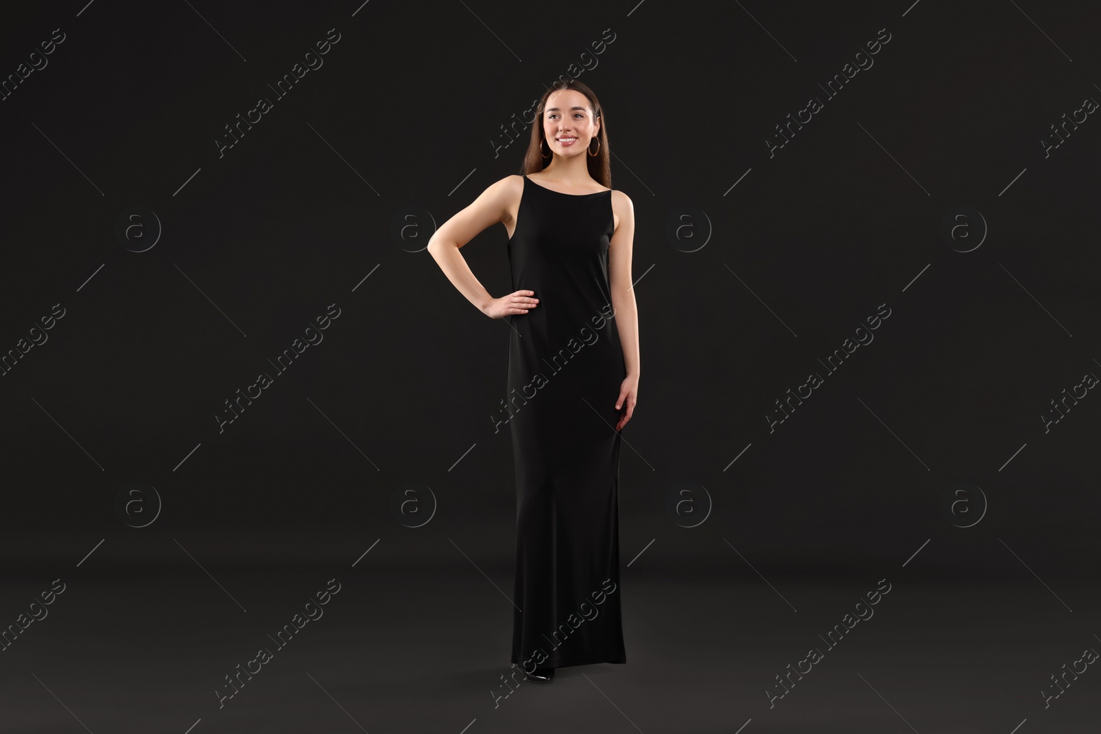 Photo of Beautiful young woman in elegant dress on black background