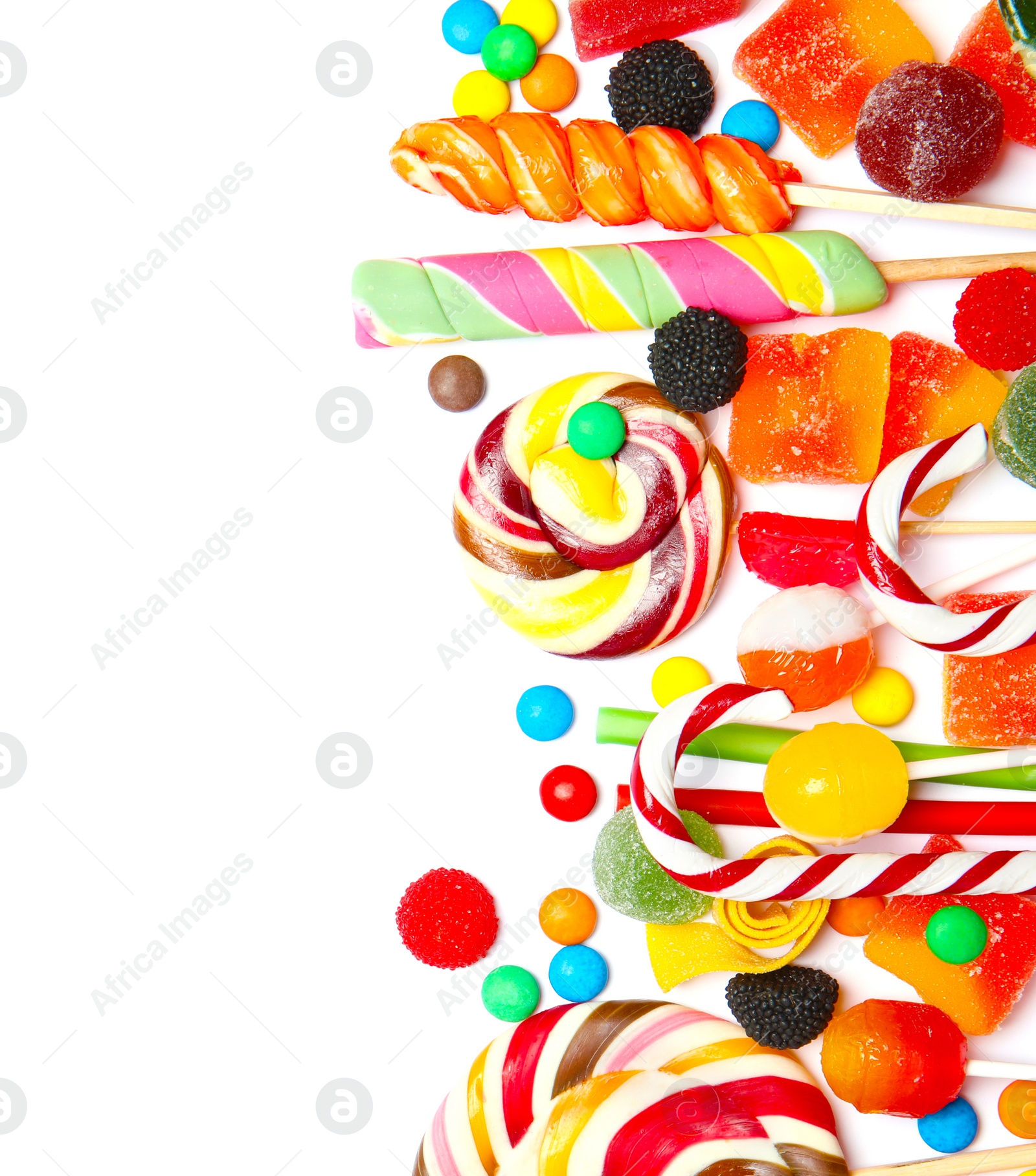 Photo of Many different yummy candies on white background, top view. Space for text